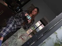 Conjunto de pijama a cuadros con ribetes en color lila, compuesto por camisa de manga larga con botones y pantalón largo.