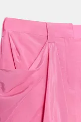 Falda mini de tiro medio color rosado, con trabillas en la cintura y bolsillos laterales con pliegues drapeados.