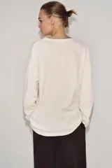 Camiseta de manga larga con tejido rústico de algodón, corte oversize, escote en pico y bajo recto.