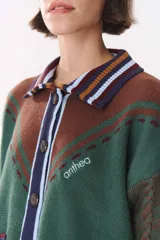 Cardigan de punto con diseño multicolor en tonos marrones, bordó y detalles en amarillo y celeste. Presenta cuello tipo polo, cierre frontal con botones, bolsillos aplicados en el frente y mangas con trama trenzada y coderas bordadas.