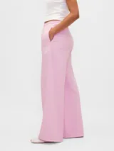 Pantalón deportivo de corte amplio y pierna ancha, color rosado, con cintura elástica y diseño holgado.