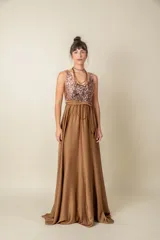 Vestido largo rojo con cuerpo de lentejuelas y falda de satén con caída fluida. Presenta escote redondo, sin mangas y un lazo en la cintura.