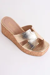 Sandalia dorada con plataforma de corcho y tiras cruzadas.