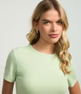 Blusa básica de manga corta y cuello redondo, confeccionada en viscosa texturizada de canalé con elastano y detalle de terminación ondulada en el bajo.