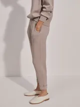 Pantalón de jogging color taupe, confeccionado en tejido DoubleSoft, con corte ajustado, pinzas delanteras y traseras, y puños enrollados en el bajo.