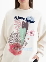 Buzo oversize de cuello redondo y manga larga, color crema. Presenta una estampa frontal con motivos florales, corazones y la frase 'A love letter to winter flowers'.