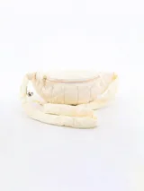 Riñonera acolchada color crema con diseño de rombos.