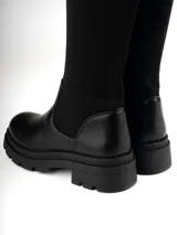 Bucaneras negras de caña alta confeccionadas en simil cuero, con elástico en la caña y suela track.