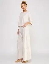Blusa corta color beige de lino y viscosa, con escote redondo, mangas tres cuartos estilo kimono y corte holgado.
