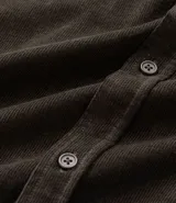 Camisa de hombre color verde oscuro, confeccionada en terciopelo, con cuello clásico, manga larga y dos bolsillos frontales con solapa y botón. Cierre frontal con botones.