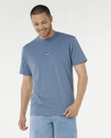 Remera Rip Curl de manga corta en color azul, con estampado gráfico en la espalda con el logo de la marca y la inscripción "Born at Bells".