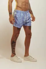 Short de baño rosado con estampado tropical de palmeras y vehículos, con cintura elástica con cordón ajustable.