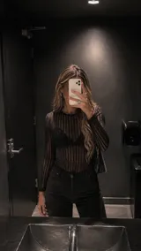 Body de manga larga con diseño de rayas verticales y acabado brillante. Presenta un tejido semitransparente ajustado al cuerpo con cuello redondo.