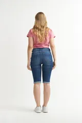 Pantalón capri de denim celeste claro, corte ajustado al cuerpo con tiro alto, bolsillos clásicos y botamangas con vuelta.