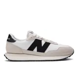 Championes urbanos New Balance modelo 237, color blanco con detalles en negro y gris, confeccionados en gamuza y malla, con logo "N" característico en los laterales y entresuela de goma.