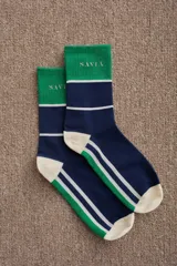Medias de caña media con diseño tricolor en blanco, verde y azul marino. Presentan el logo de la marca bordado en la parte superior y puntera y talón reforzados en color verde.