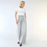 Jean de corte wide leg y tiro alto, confeccionado en denim de color gris lavado. Presenta pinzas en la cintura, cierre frontal con botón y bolsillos laterales.