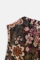 Top sin mangas con cuello redondo y fruncido, confeccionado en tejido negro con estampado floral en tonos rosados y marrones, e hilo metalizado vertical.