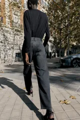 Jeans de tiro alto, corte recto y largo, color negro lavado, con abalorios brillantes distribuidos por toda la prenda.