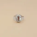 Anillo tipo sello de plata 925 con aplique central de oro 9k que representa el símbolo de la medicina (caduceo). Presenta un acabado texturizado en el fondo del diseño central.