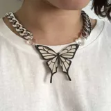 Collar con cadena gruesa plateada, eslabones grandes y dije de mariposa blanco y negro.