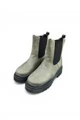 Bota Chelsea de cuero sintético marrón, con paneles laterales elásticos negros, suela chunky acanalada de goma negra y presilla trasera.