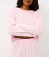 Pijama de dos piezas confeccionado en plush, compuesto por una remera de manga larga con cuello redondo y un pantalón largo de corte recto con cintura elástica. Presenta un diseño con textura embossada en relieve en toda la prenda.