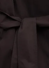 Chaqueta larga marrón de diseño recto, confeccionada en mezcla de algodón con solapas amplias, manga larga y cinturón tipo batín. Cuenta con detalle de tabla en la parte posterior y forro interior de viscosa.