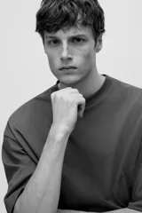 Remera marrón de algodón pesado, corte oversized, con cuello redondo ribeteado, hombros caídos y bajo recto.