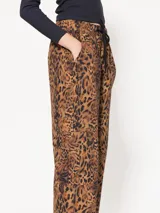 Pantalón babucha de algodón con estampado animal print, cintura elastizada con cordón de ajuste, puños elastizados y bolsillos plaque con tapa y broche snap negro.