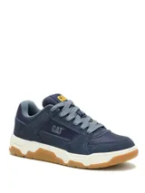 Championes Cat modelo Theorem, de estilo urbano inspirado en los años 90. Confeccionados en una combinación de ante y nylon, presentan un diseño en tonos azul marino con entresuela de EVA blanca y suela de goma color caramelo. Incluyen el logo de la marca en el lateral y la lengüeta.