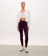 Campera rompevientos deportiva cropped de color blanco, con capucha, cierre frontal y puños elásticos. Confeccionada en poliamida, presenta un diseño ligero y funcional.