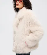 Saco corto de pelo artificial en color beige, con cuello amplio, mangas largas y diseño holgado. Cuenta con forro interior de poliéster.