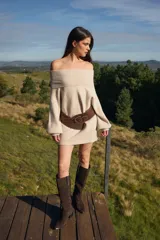 Sweater de punto con textura acanalada, cuello alto tipo polerón, mangas largas abuchonadas y puños anchos.