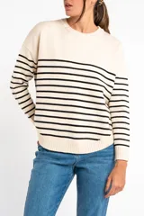 Sweater de punto con diseño a rayas horizontales negras sobre base color crema, cuello redondo, mangas largas y puños acanalados.