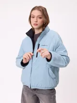 Campera puffer reversible de la marca Rusty, con diseño capitoneado. Presenta cuello alto, cierre frontal completo y logo bordado en el pecho. El interior es de un tono contrastante.