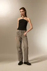 Top negro al cuerpo con diseño halter, confeccionado en poliéster. Presenta un detalle de aro metálico en el centro del escote y breteles finos.