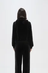 Campera con capucha de terciopelo color bordó, con cierre frontal, bolsillos tipo canguro y texto bordado en el pecho.