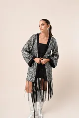 Kimono corto con estampado de rayas plateadas y negras, mangas campana con puños negros y flecos negros en el dobladillo.