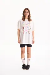Remera oversize de algodón blanca con estampado multicolor de motivos veraniegos y la frase "Dolce Vita" en el centro.