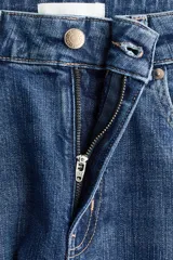 Jean wide leg de tiro alto en denim de algodón con leve elasticidad. Presenta diseño de cinco bolsillos, presillas para cinturón y cierre frontal con botón metálico.
