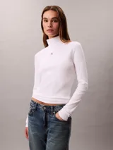 Top de manga larga Calvin Klein color blanco, confeccionado en punto fino de algodón y licra. Presenta cuello tortuga, ajuste ceñido al cuerpo y un pequeño parche con el monograma de la marca en el pecho.