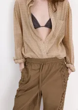 Pantalón marrón de corte recto, con cintura ajustable elastizada y cordón, y detalle de franja lateral bordada con diseño calado.