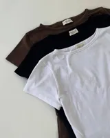 Remera blanca de corte crop, cuello redondo y mangas cortas.