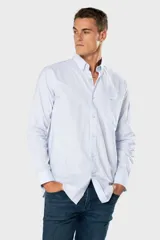 Camisa Oxford lisa de color celeste, con cuello abotonado, manga larga, cierre frontal de botones y un bolsillo aplicado en el pecho con detalle bordado.