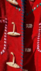 Chaqueta roja de cuero 100% artesanal, con pasamanería y detalles de costura en tiento. Posee bolsillos plaqué frontales, cuello camisero, botones de cuero alargados tipo duffel y forro interno.