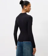 Blusa de punto canalé color negro, con cuello alto, manga larga y diseño ajustado con dobladillo estilo peplum.
