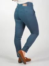 Pantalón chupín de gabardina elastizada color azul petróleo, tiro alto, con alforzas en delantero y trasero, pretina ancha con doble botón, bolsillos traseros falsos y terminación de bajo con puño y botón.