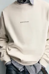 Sudadera de corte regular fit confeccionada en tejido de algodón con interior afelpado. Presenta cuello redondo, manga larga, acabados en rib y estampado de texto a contraste en el frente.