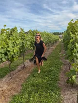 Vestido corto tejido en lurex negro con detalles en blanco, de corte holgado, mangas cortas y flecos en el ruedo.